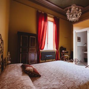 摩德纳萨洛托阿尔阿提酒店的一间卧室配有一张带红色窗帘的大床