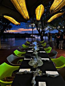 卡蒂马穆利洛Kubu & Kwena Lodge的长排桌子,有绿色的椅子和桌子