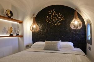Éxo GoniáAecon Suites的一间卧室配有一张石墙床