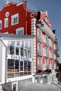 布克维Chevalier Hotel & SPA的一座红色的建筑,上面标有酒店标志