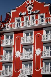 布克维Chevalier Hotel & SPA的一座红色的建筑,上面有标志