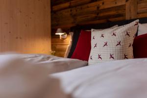 穆劳附近圣洛伦岑Kreischberg Suites by ALPS RESORTS的一间卧室配有两张带白色床单和红色枕头的床。