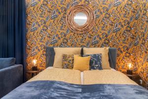 布达佩斯Grand Suites Corvin的一间卧室配有一张床和一面镜子的墙壁