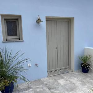 锡米Amalthea Luxury Suites的两棵盆栽植物的蓝色墙上的门