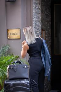 波尔多波尔多中心丘吉尔酒店的女人带着行李站在外面