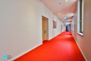 列日酷洛内列日酒店的走廊上铺有红地毯的走廊