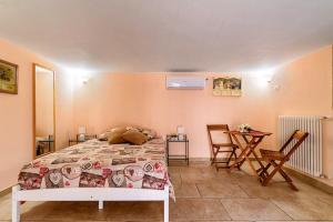 莱切省卡斯特罗L' ATTICO CastroSalento的卧室配有一张床和一张桌子及椅子