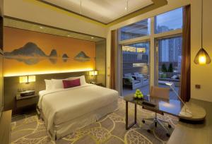 香港香港九龍東皇冠假日酒店的酒店客房配有一张床、一张书桌和一张书桌。