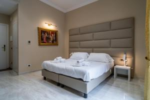 圣雷莫Correnti Boutique Hotel Gold的一间卧室配有一张大床和大床头板