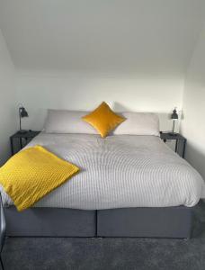波塔费里School house Portaferry的床上有两张黄色枕头