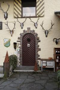 雷希Jagdhaus Rech - Ahr的一座带鹿头的棕色门的建筑