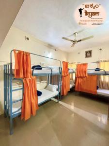 马迪凯里iKyam (The Backpackers Hostel/Homestay)的带3张双层床和橙色窗帘的房间