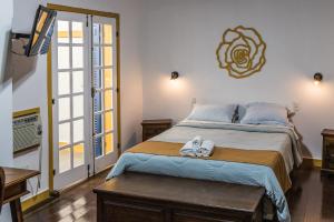 圣若昂-德雷Pousada Casarão的一间卧室配有一张大床和毛巾