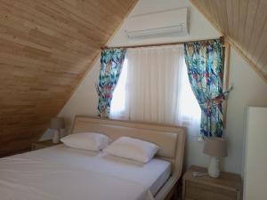 契拉勒Bellerofon villa的一间卧室配有带两个枕头的床和窗户