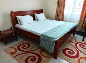 蒙巴萨Sandy Luxury Home, Nyali的一间卧室配有一张大床和木制床头板