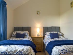 北伍顿卡瑞美度假屋的一间卧室配有两张床和一个带灯的床头柜
