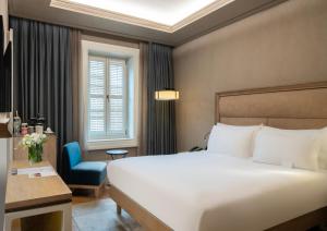 伊斯坦布尔10 Karakoy的酒店客房,配有一张床和一张蓝色椅子