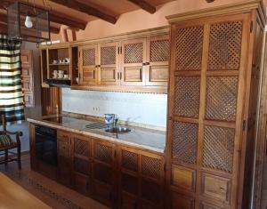 布维翁卡萨尔布哈拉公寓酒店的一个带木制橱柜和水槽的厨房