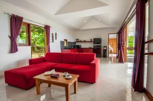罗威那罗维纳丹绒别墅的客厅里一张红色的沙发,配有桌子