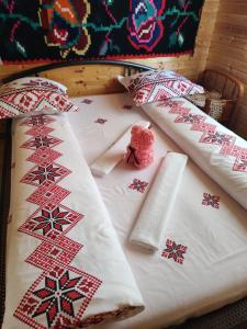 BudeştiCabanele Rus的一张带红色和白色枕头的床