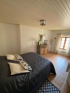 坎松Coquette maison de village pour 4 pers的一间卧室配有一张带黑色床单的床和一扇窗户。