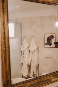 勒博塞Le Clos Serein的镜子反射着浴室,浴室设有水钩上的白色毛巾