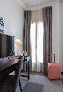 格拉纳达Hotel Macià Plaza的酒店客房设有一张书桌、一台电脑和行李箱