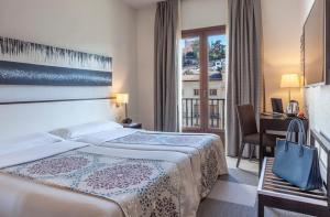 格拉纳达Hotel Macià Plaza的酒店客房配有两张床和一张书桌