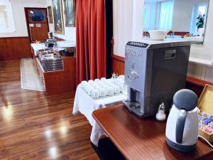洛约什米热Liza Aqua & Conference Hotel的一间设有桌子和咖啡机的客房