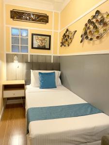 麦克坦Little Norway Guesthouse - Mactan Cebu International Airport的小卧室配有一张带蓝色枕头的床