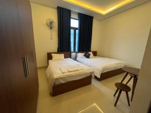 广义Nhà Nghỉ Ánh Dương的酒店客房设有两张床和窗户。