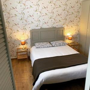 LesperonHôtel et RESTAURANT traditionnel L' Escalandes的一间卧室配有一张大床和两盏灯