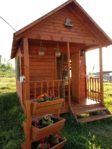 KegetiГостевой дом Темирлан的小木屋设有门廊和一些鲜花
