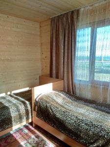 KegetiГостевой дом Темирлан的一间卧室设有两张床和窗户。