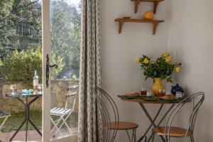 圣保罗-德旺斯Le Mas des Gardettes的窗户客房内的桌椅
