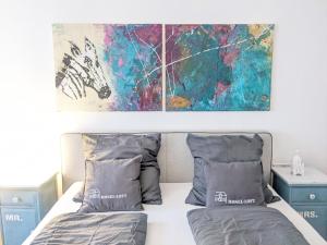 贝尔恩卡斯特尔-库斯Mosel-Loft的卧室配有一张床,墙上挂有绘画作品