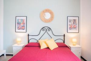 莫内利亚Vespa Apartments的一间卧室配有一张红色床罩的床