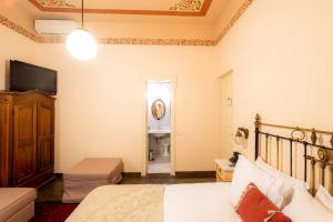 波尔塔里亚阿肯提克纳欧米迪酒店的一间卧室配有一张床、一台电视和一间浴室。