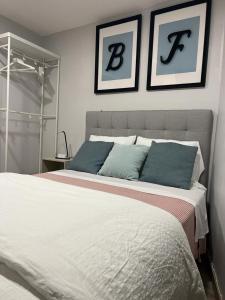 波尔图BF Suites & Apartments的卧室配有一张大床,墙上挂有两张照片