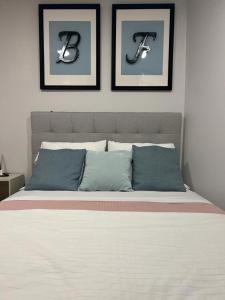 波尔图BF Suites & Apartments的卧室配有一张墙上三幅照片的床