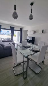 拉奥利瓦Casilla de Costa Luxury home的客厅配有玻璃桌和白色椅子