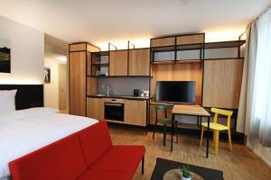 辛根S12 - Boardinghouse by Hotel Trezor的酒店客房设有一张床、一张书桌和一台电视机。