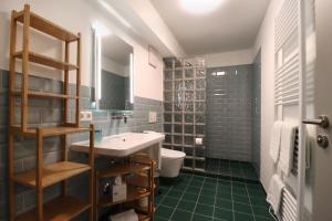 辛根S12 - Boardinghouse by Hotel Trezor的浴室设有水槽、卫生间和绿色瓷砖。