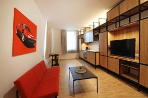 辛根S12 - Boardinghouse by Hotel Trezor的客厅配有红色沙发和电视