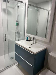 波尔图BF Suites & Apartments的浴室配有盥洗盆和带镜子的淋浴
