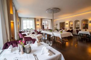梅明根维西斯罗斯酒店的一间设有白色桌子和紫色椅子的用餐室