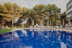 沃迪切Villa Arausa的游泳池,带椅子和遮阳伞
