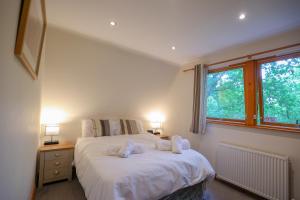 查德利Lodge Nine - A Beautiful Holiday Home in Devon的一间卧室配有一张床,上面有两条毛巾