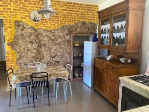 内比达Casa Vacanza Sa dommu de Teresa的厨房配有桌椅和石墙