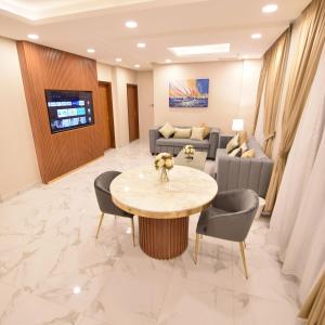 科威特الدانة للشقق الفندقية的一间设有桌子和沙发的等候室